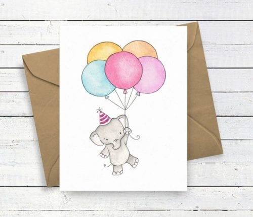 greetings card with elephant wearing party hat and holding balloons