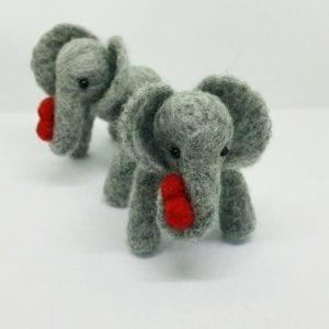 small needlefelted elephant holding a heart
